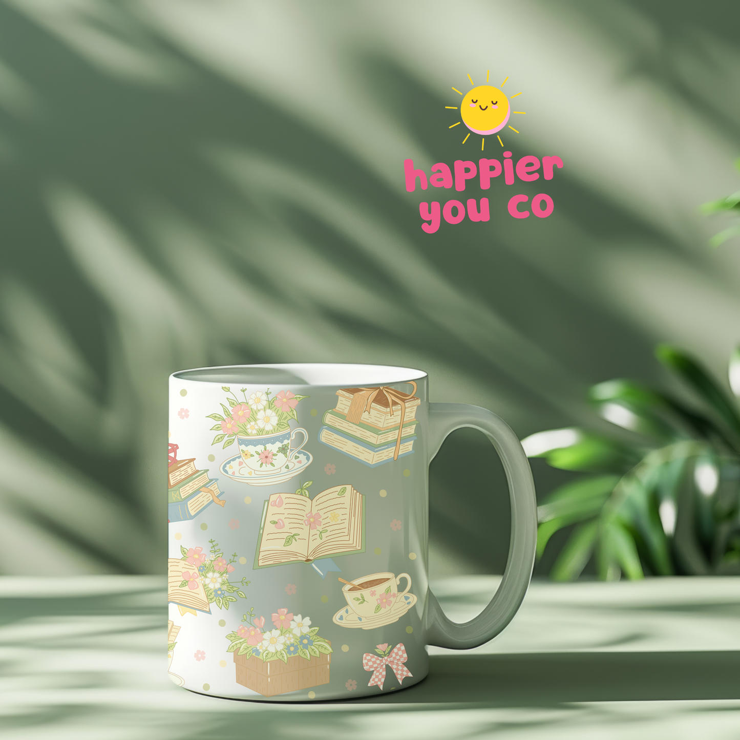 Decorative mug with book and tea design on a light green background with 'happier you co' logo.