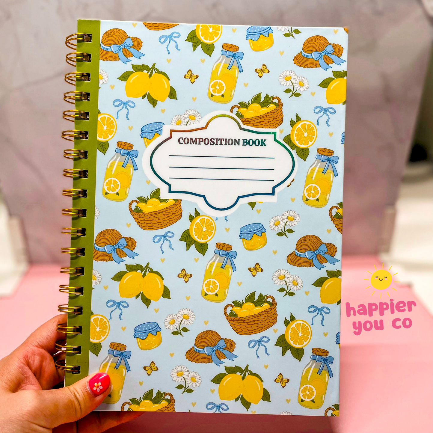 Composition book with lemon and bottle pattern held by a hand