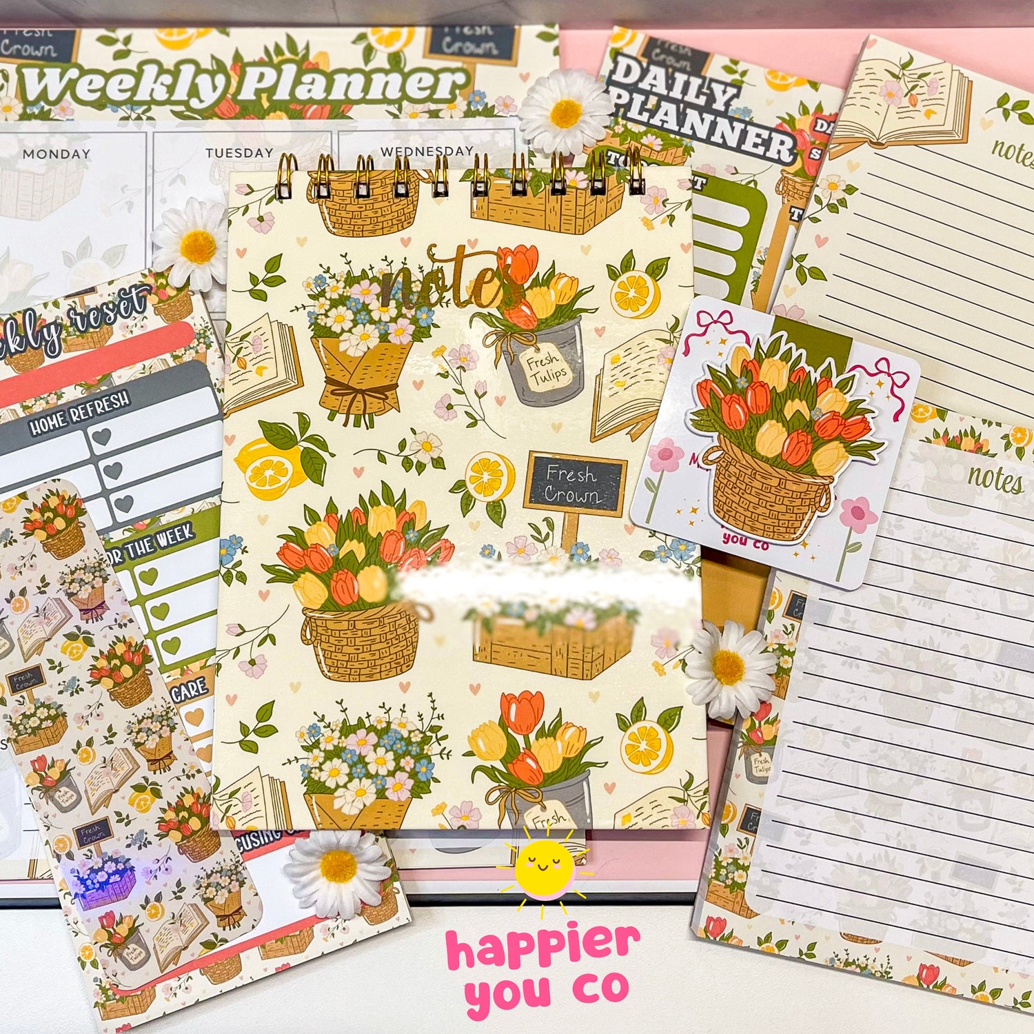 Variety of stationary products that includes notepads, notebooks, planners, bookmarks featuring a floral design