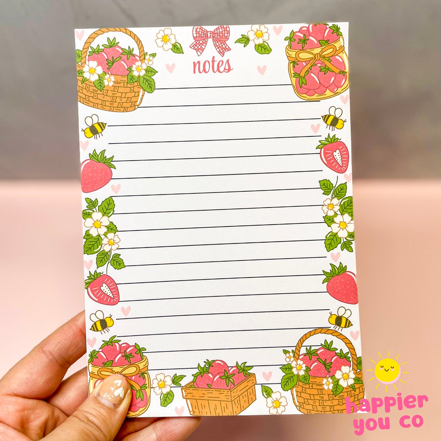 Notepad with strawberry and basket design held by a hand