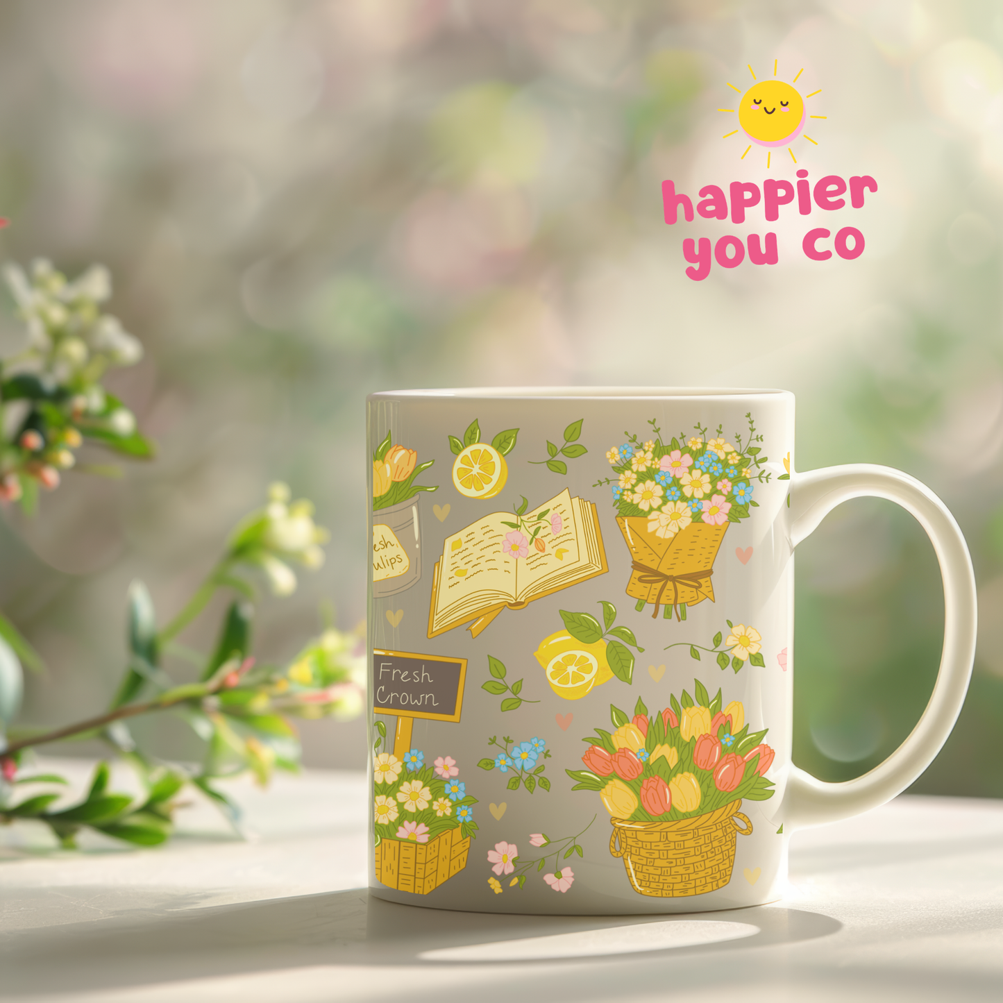 Mug with floral and book illustrations on a blurred natural background, featuring the 'happier you co' brand.