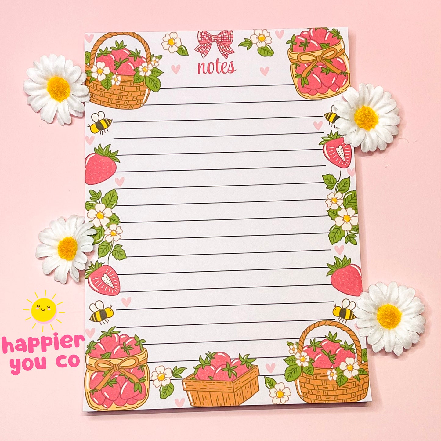 Decorative notepad with strawberry and flower designs on a pink background