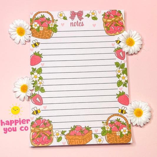 Decorative notepad with strawberry and flower designs on a pink background