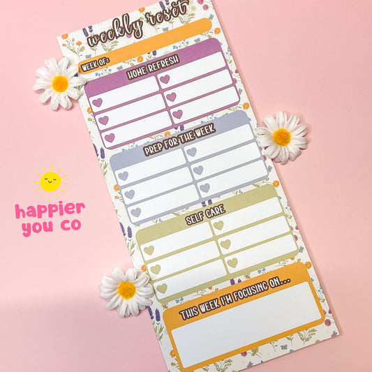 Weekly planner sheet with floral design on a pink background, featuring the brand 'happier you co'.