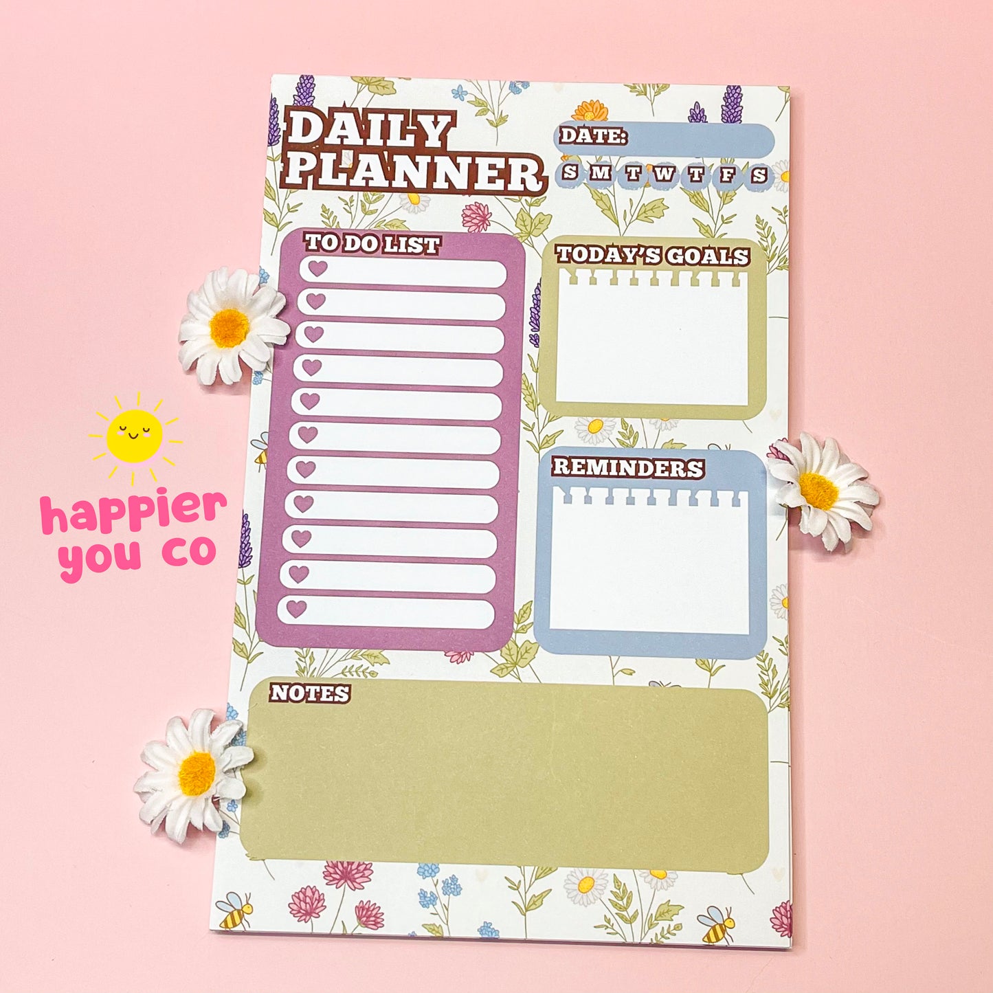 Daily planner with various sections on a pink background with flowers.
