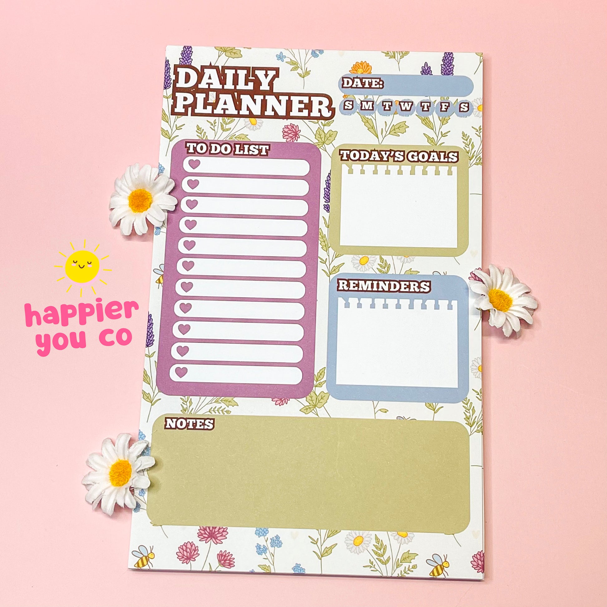 Daily planner with various sections on a pink background with flowers.