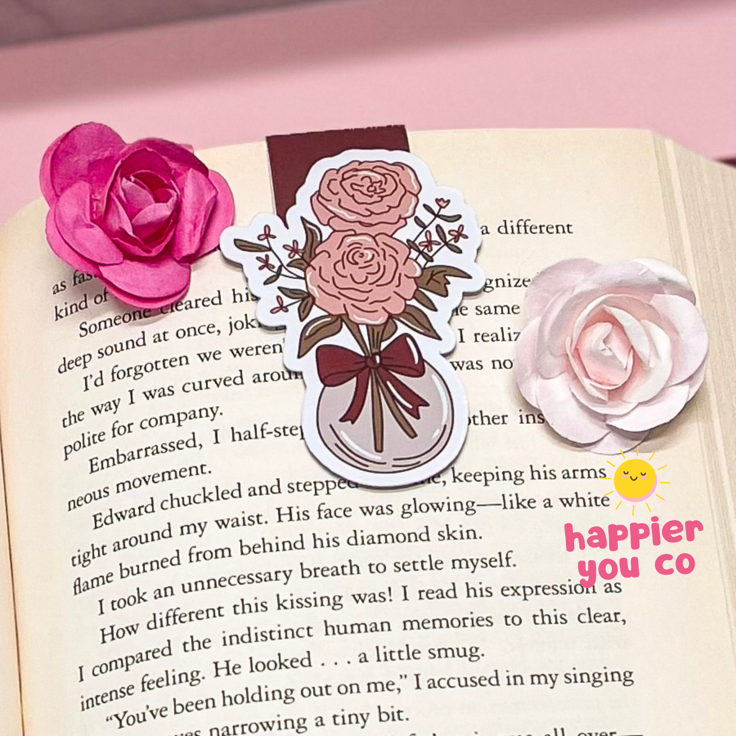Decorative floral bookmarks on an open book with a pink flower and text.