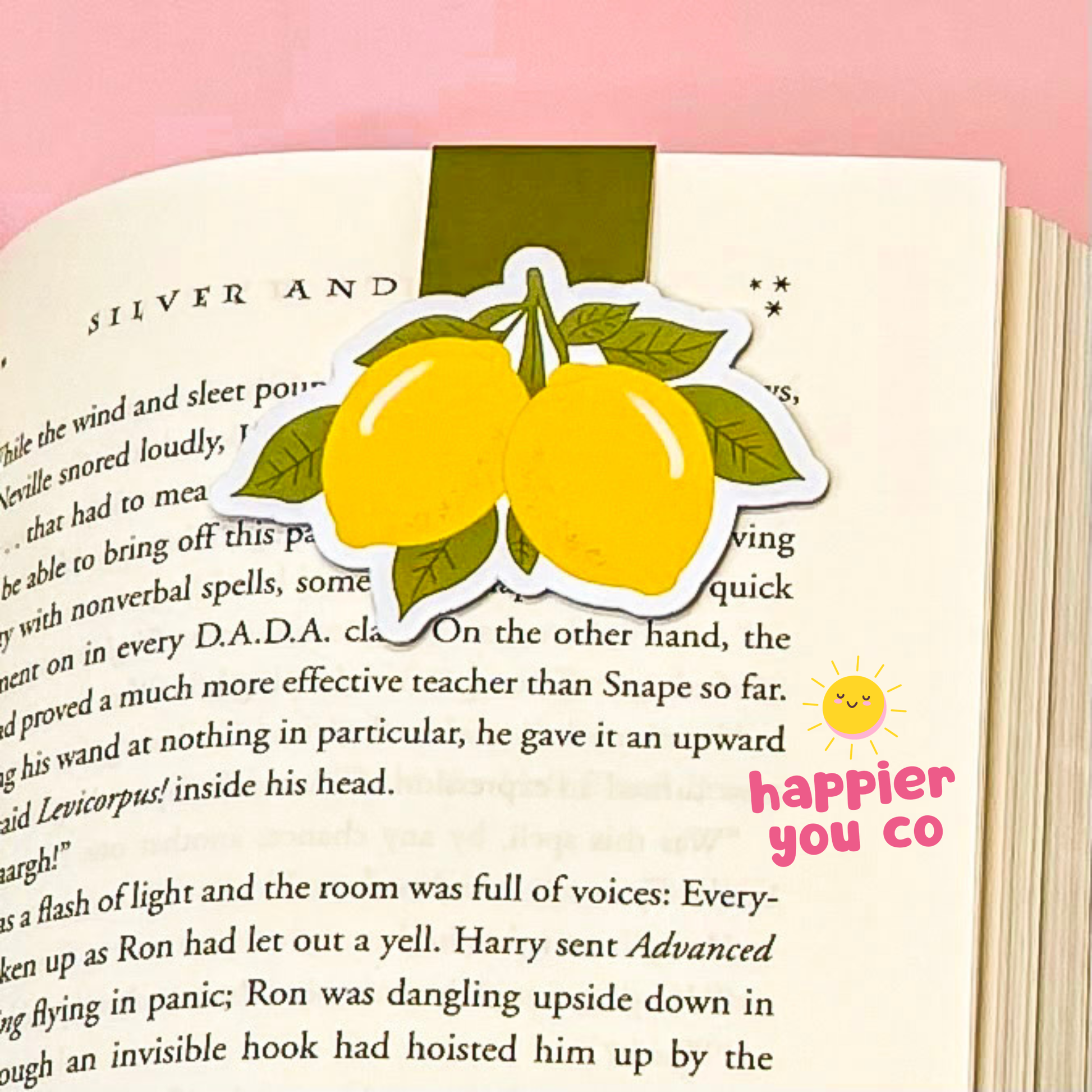 Lemon-themed magnetic bookmark on a book with 'happier you co' text