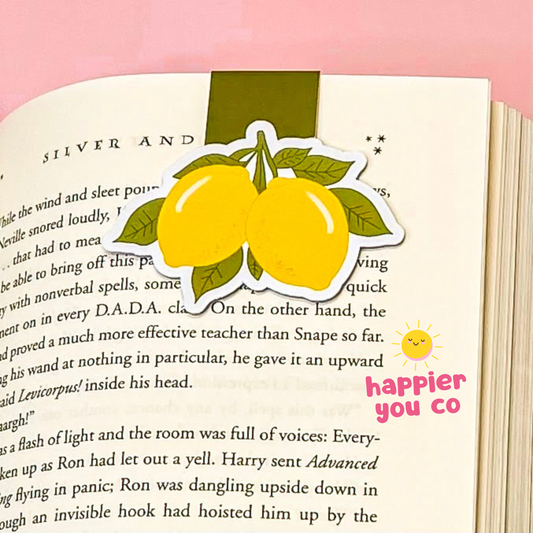 Lemon-themed magnetic bookmark on a book with 'happier you co' text
