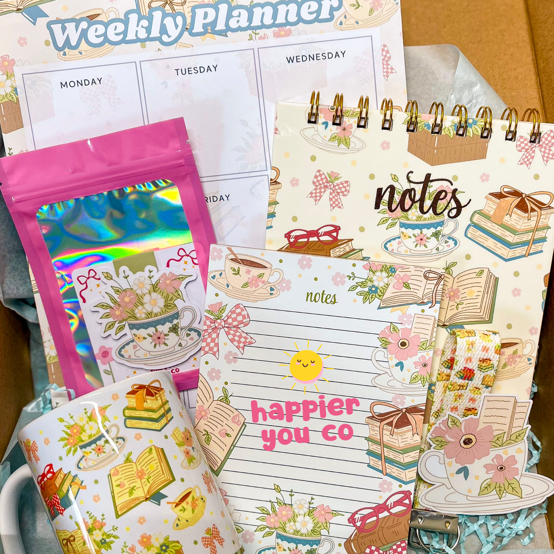 Collection of stationery items including a weekly planner, stickers, and a notepad with decorative designs.