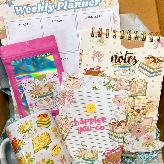 Collection of stationery items including a weekly planner, stickers, and a notepad with decorative designs.