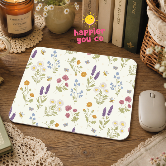 Floral mouse pad on a wooden desk with books and a candle