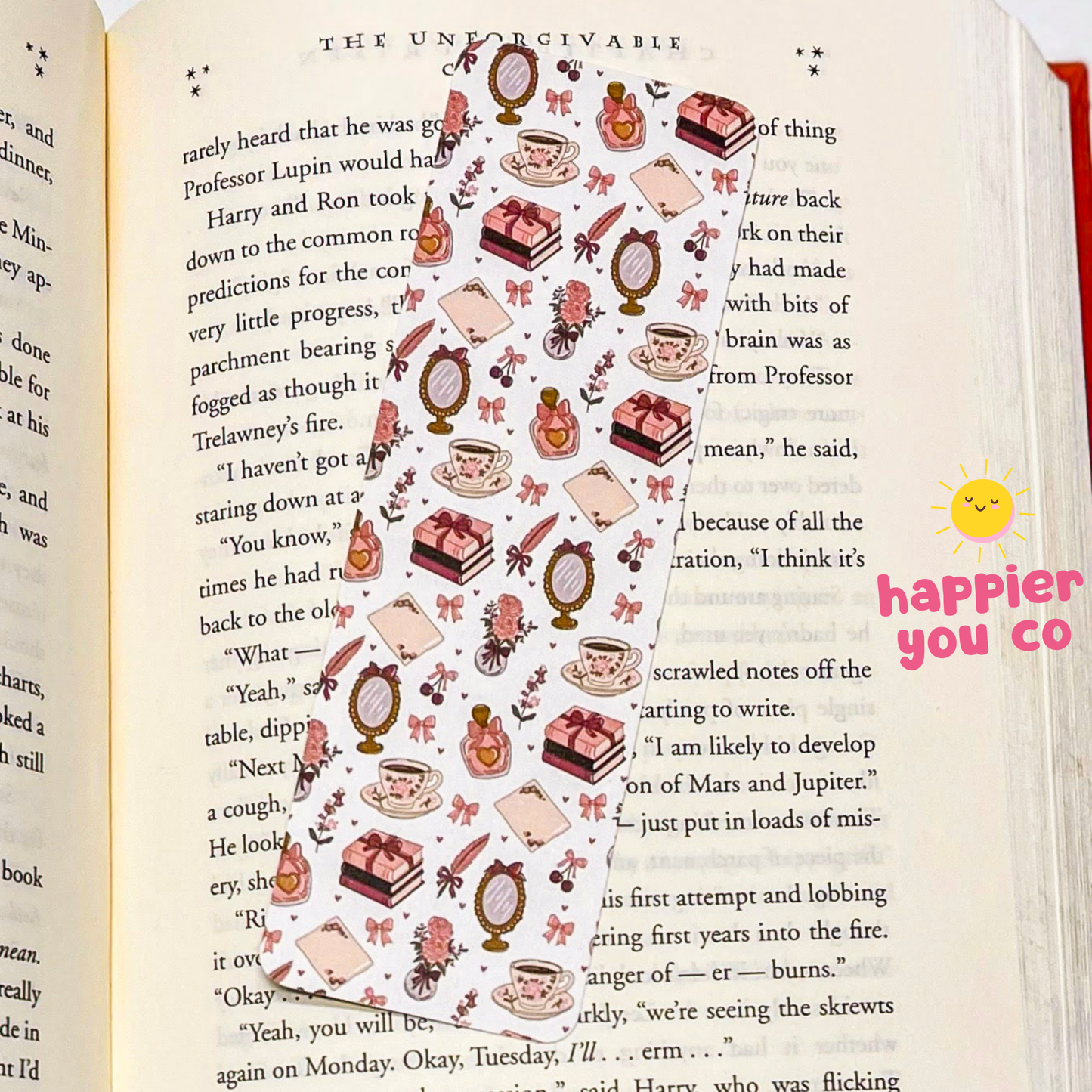 Decorative bookmark with illustrations of tea cups, cakes, and other items on a page with text.