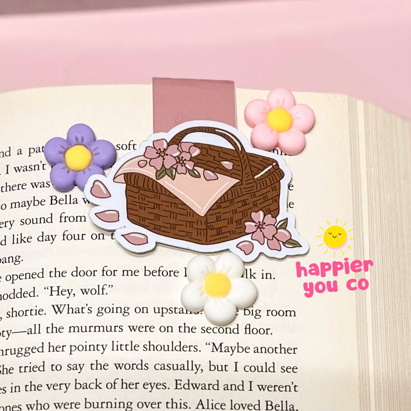 Magnetic bookmark of a picnic basket with flowers on a book page
