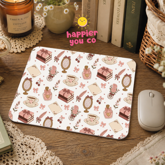 Mouse pad with decorative pattern on a wooden desk with books and a candle.