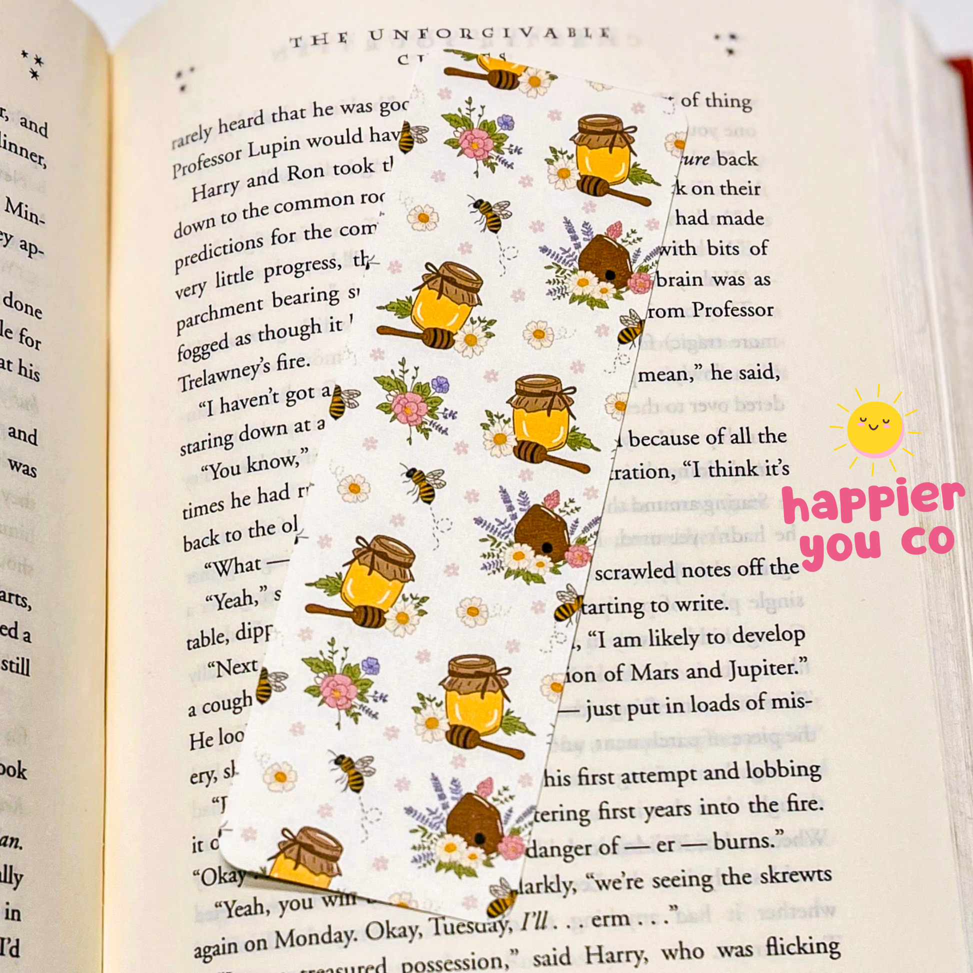 Open book with decorative bookmark of bees and honeycombs on a white background