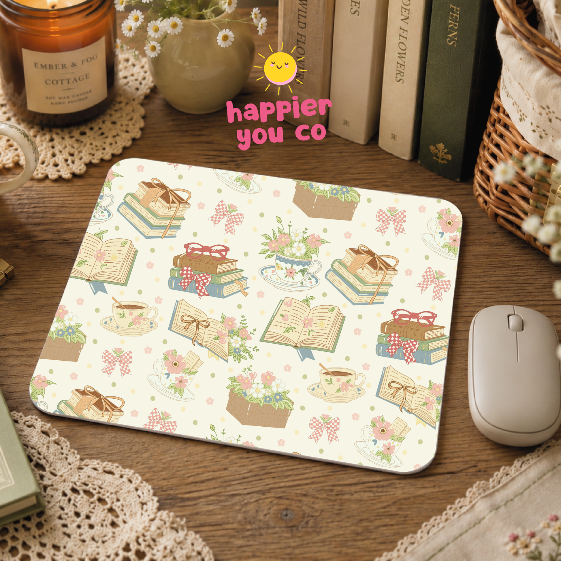 Decorative mouse pad with book and flower pattern on a wooden desk.