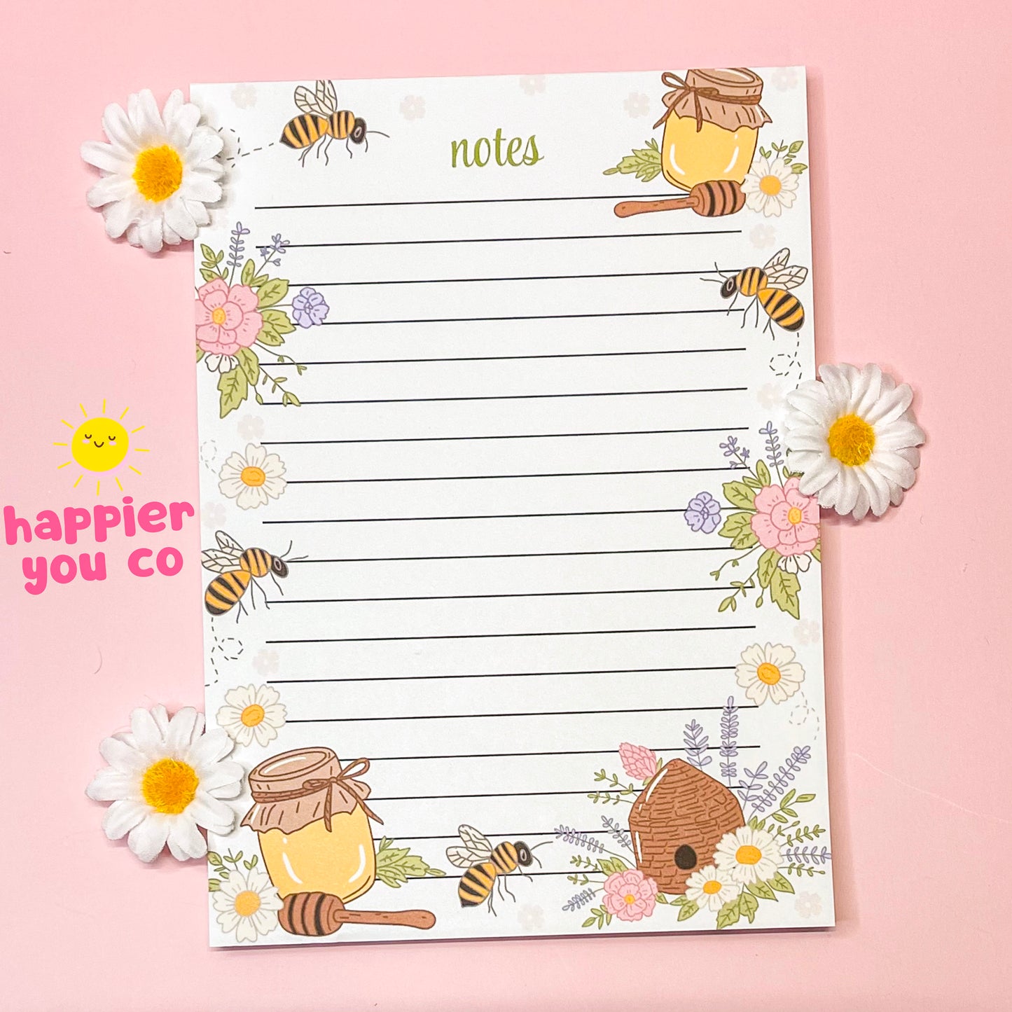 Notebook with bee and honey design on a pink background