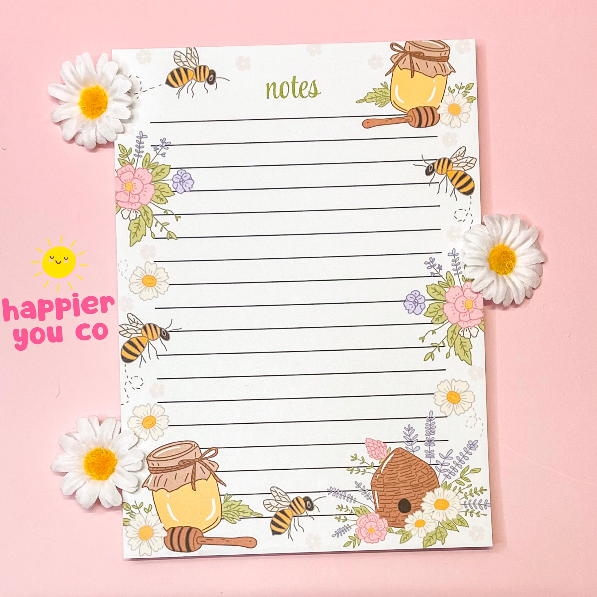 Notebook with bee and honey design on a pink background