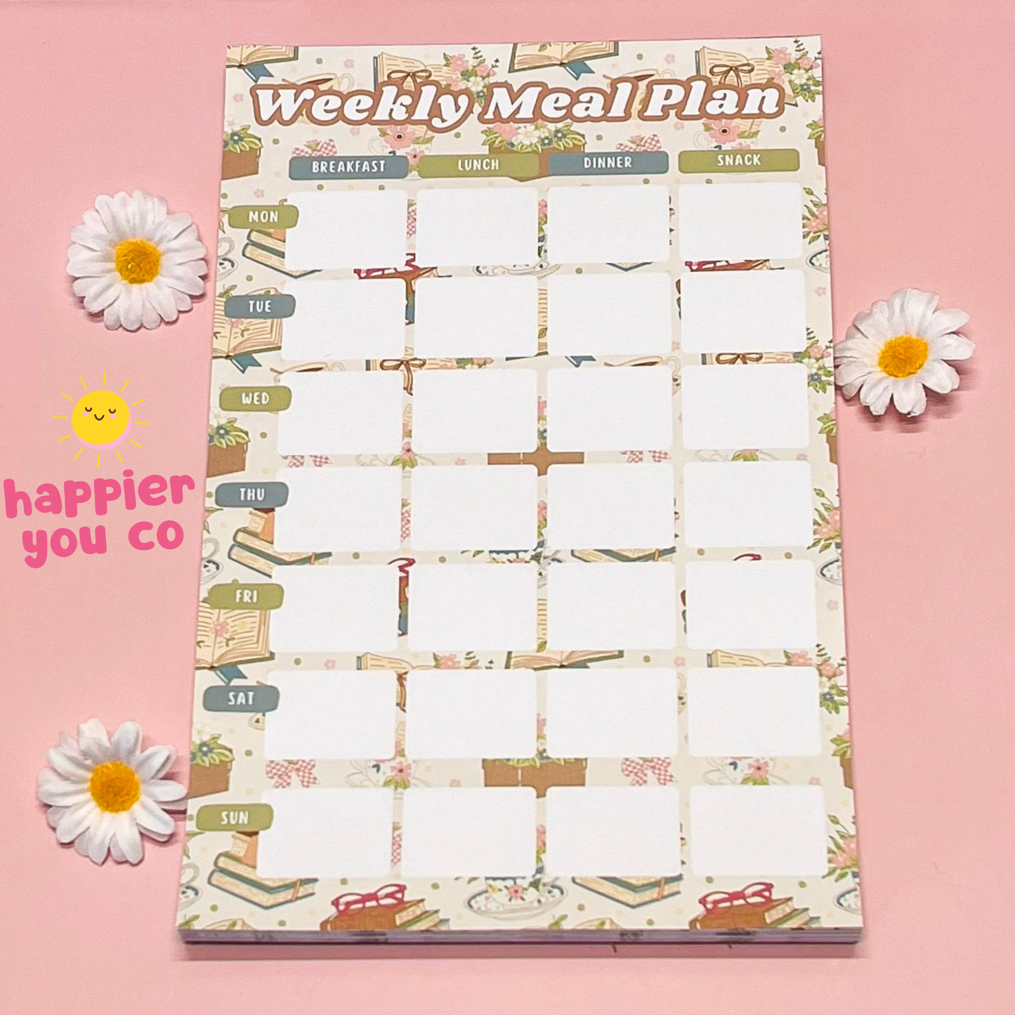 Weekly meal plan notepad with floral decorations on a pink background