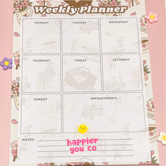 Weekly planner with floral design and 'happier you' text on a pink background