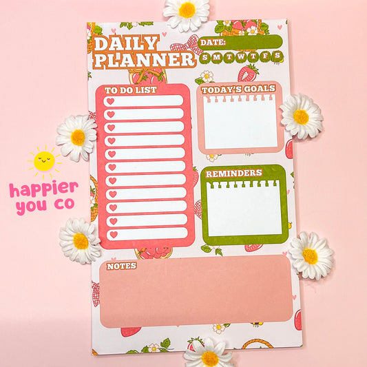 Daily planner with various sections on a pink background with daisies