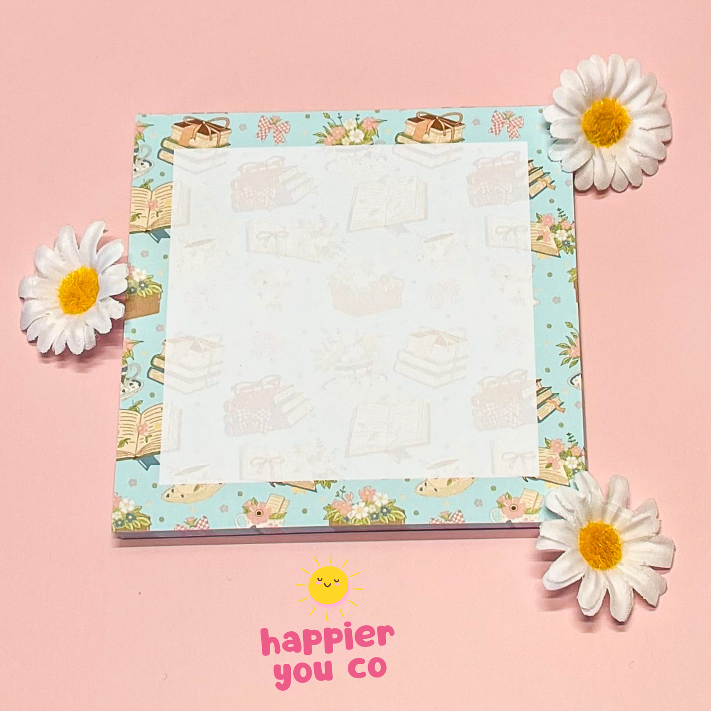 Notepad with floral design on a pink background with flowers around