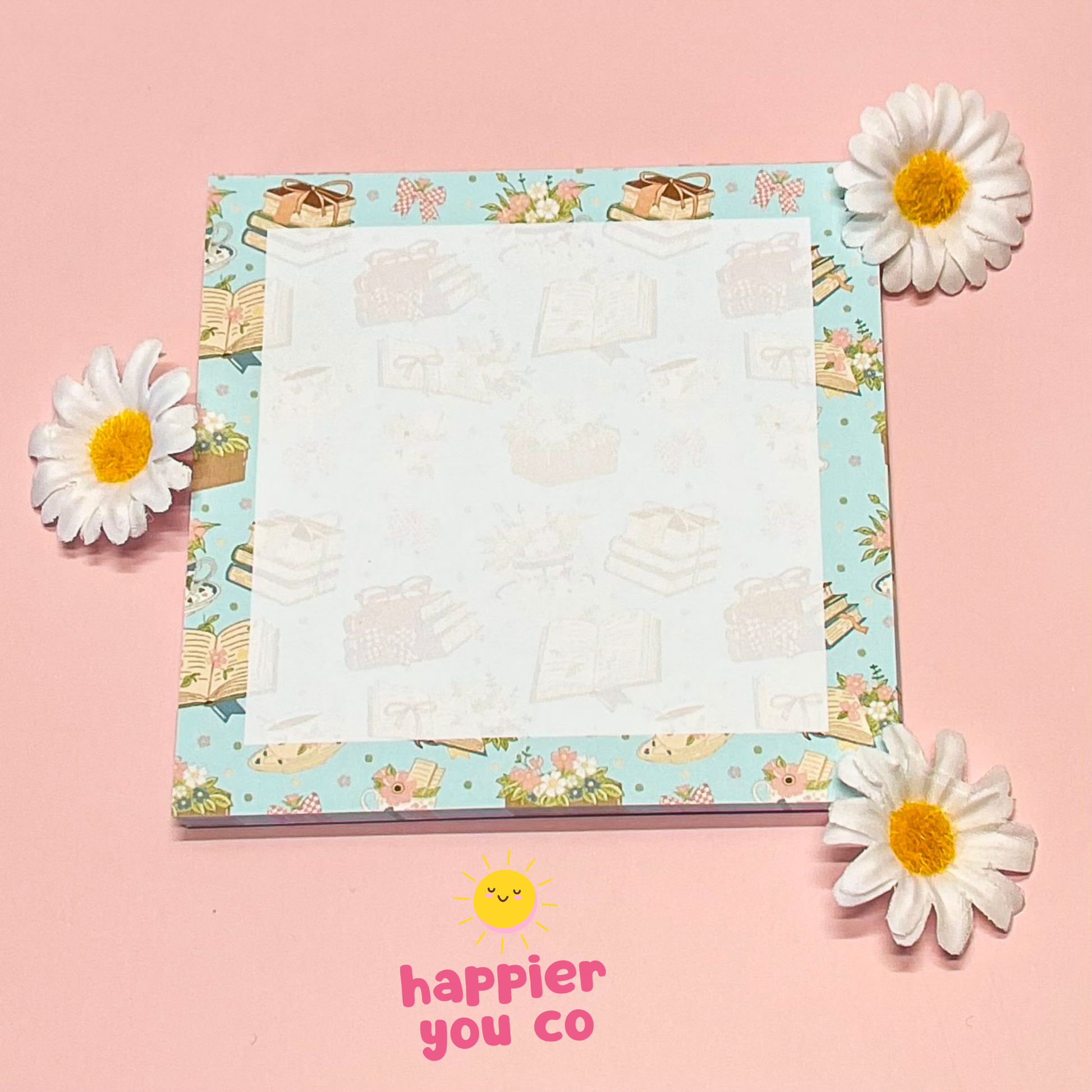 Notepad with floral design on a pink background with flowers around