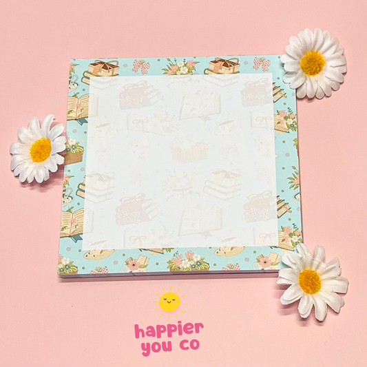 Notepad with floral design on a pink background with flowers around