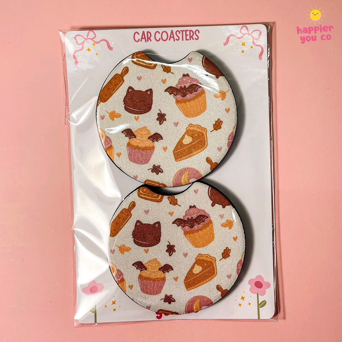 A pair of round car coasters with a cute dessert pattern, packaged on a white backing card labeled 'CAR COASTERS' against a solid pink background.