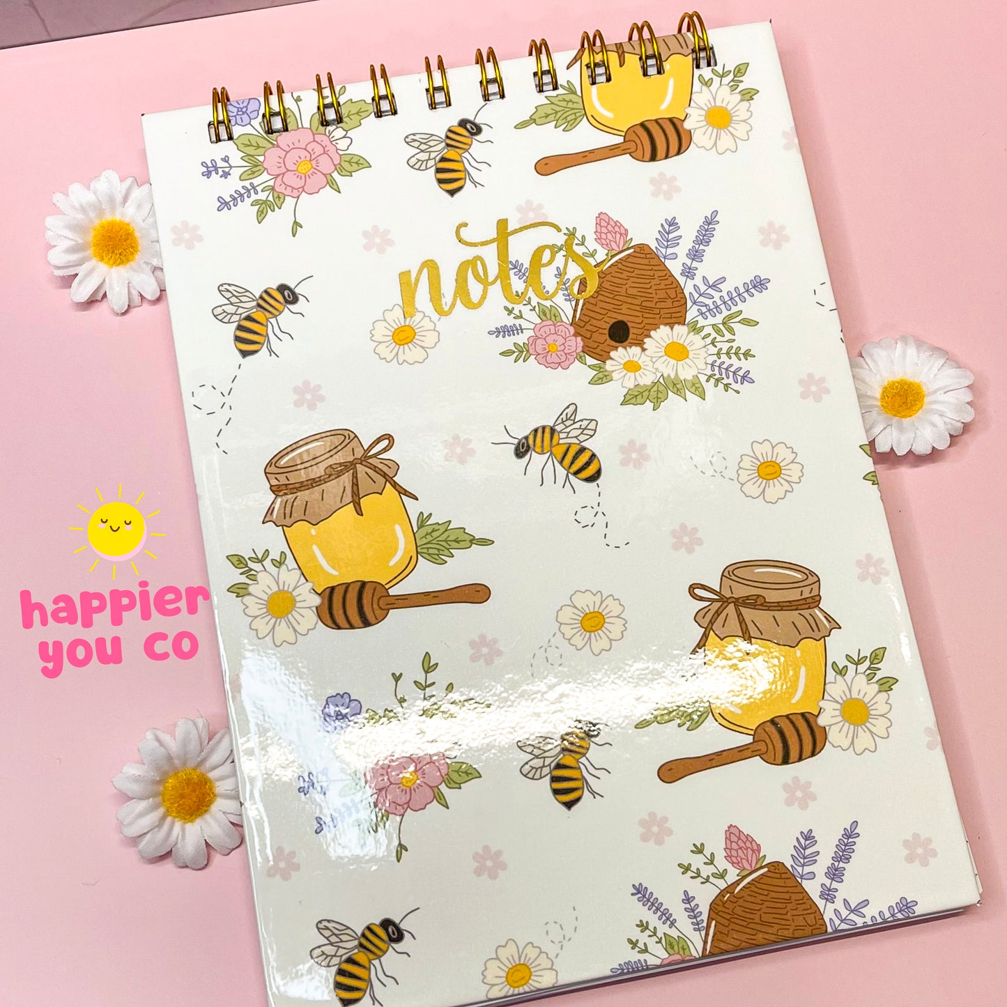 Notebook with bee and honey design on a pink background