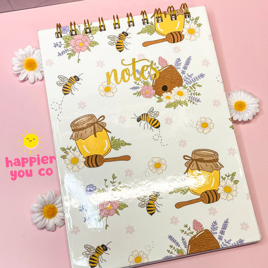 Notebook with bee and honey design on a pink background