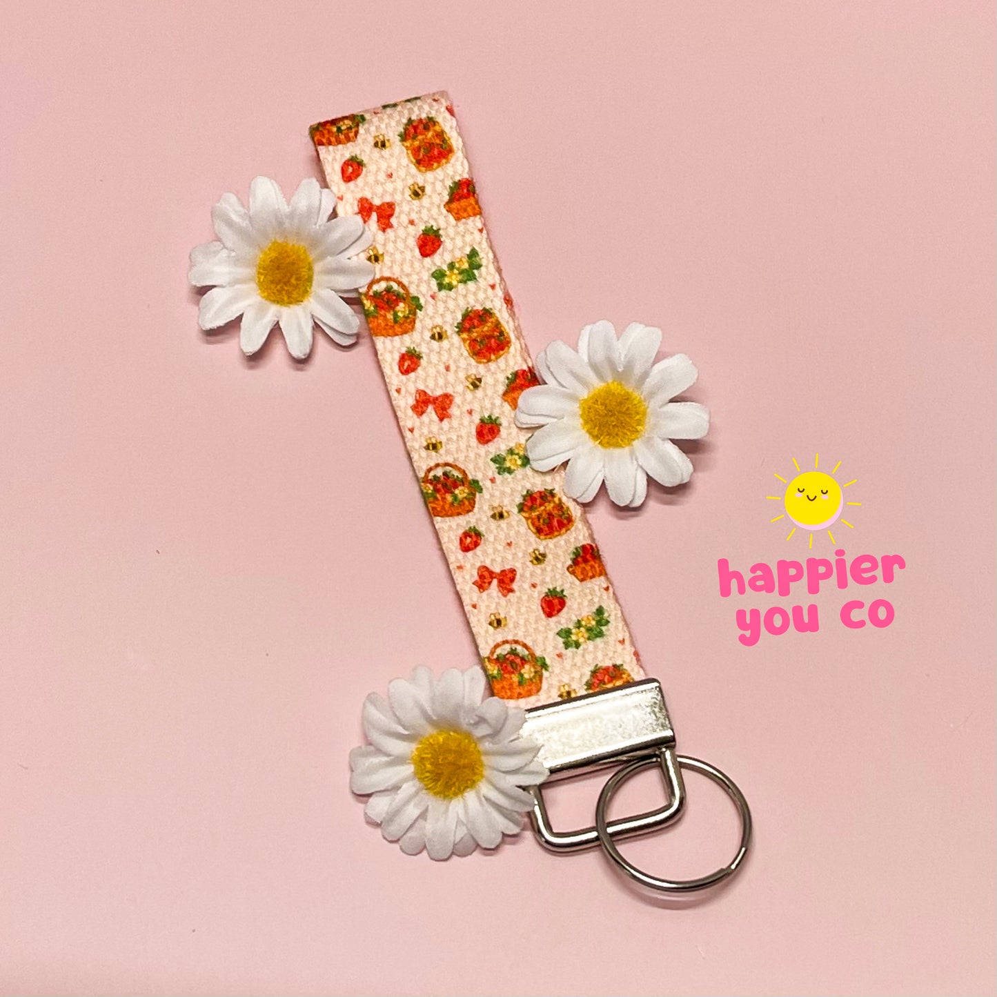 Keychain with floral pattern and strawberries on a pink background with daisies.