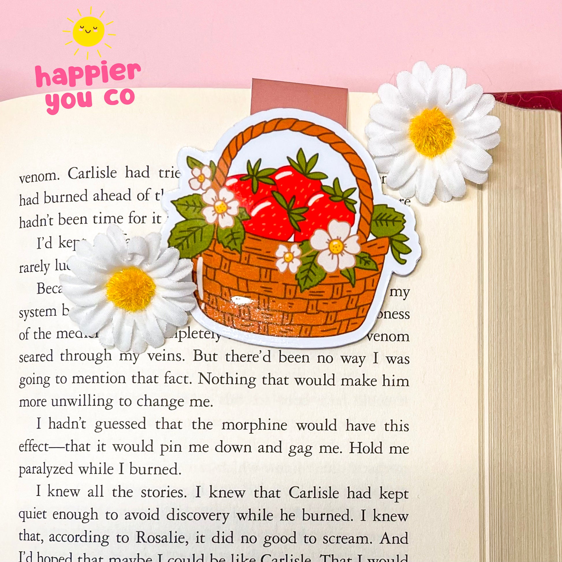 Decorative magnetic bookmark of a basket with strawberries and flowers on a book page with text.