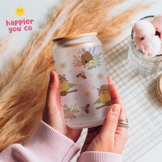 Person holding a can with bee and honey design, 'happier you co' branding visible.