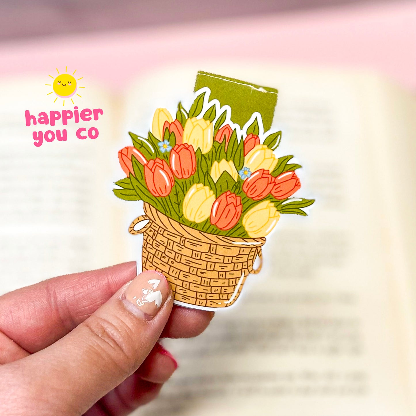 Magnetic bookmark of a bouquet of tulips held by a hand with 'happier you co' text.