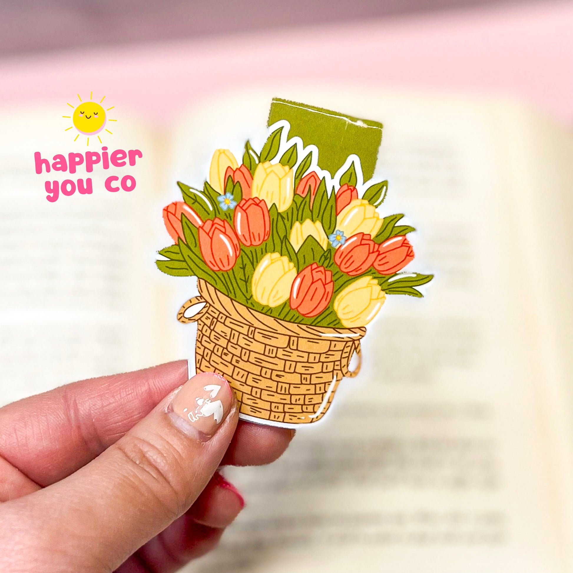 Magnetic bookmark of a bouquet of tulips held by a hand with 'happier you co' text.