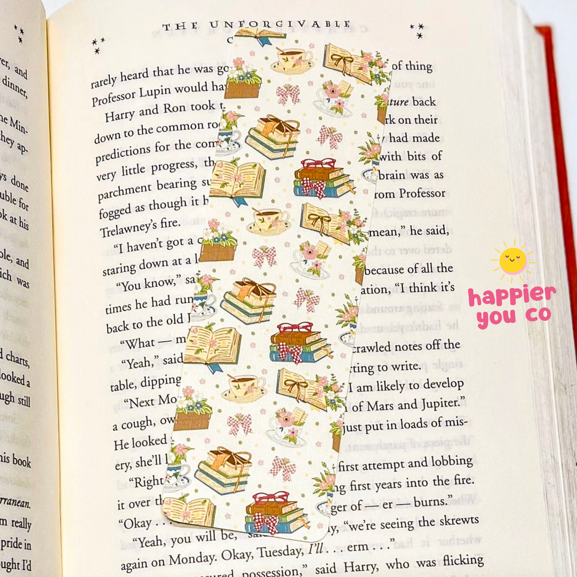 Open book with decorative bookmark and 'happier you co' text overlay