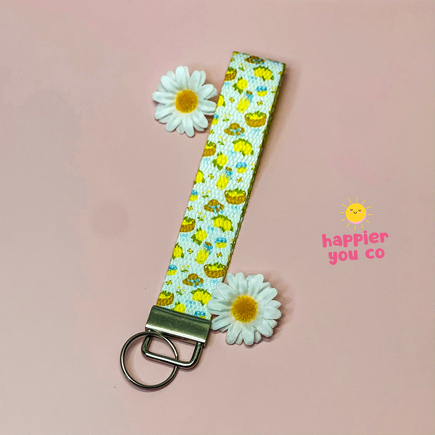 Floral keychain with daisies on a pink background, featuring 'happier you co' branding.