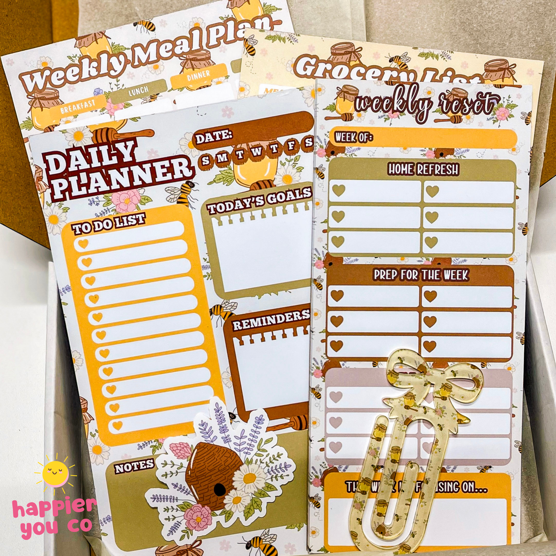 Set of planner stickers with daily and weekly meal planning templates on a wooden surface.