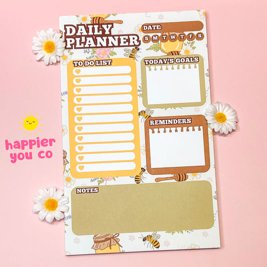 Daily planner sheet with various sections on a pink background, featuring the brand 'happier you co'.