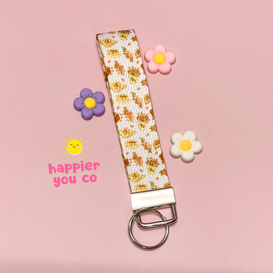 Floral patterned keychain with decorative flowers on a pink background