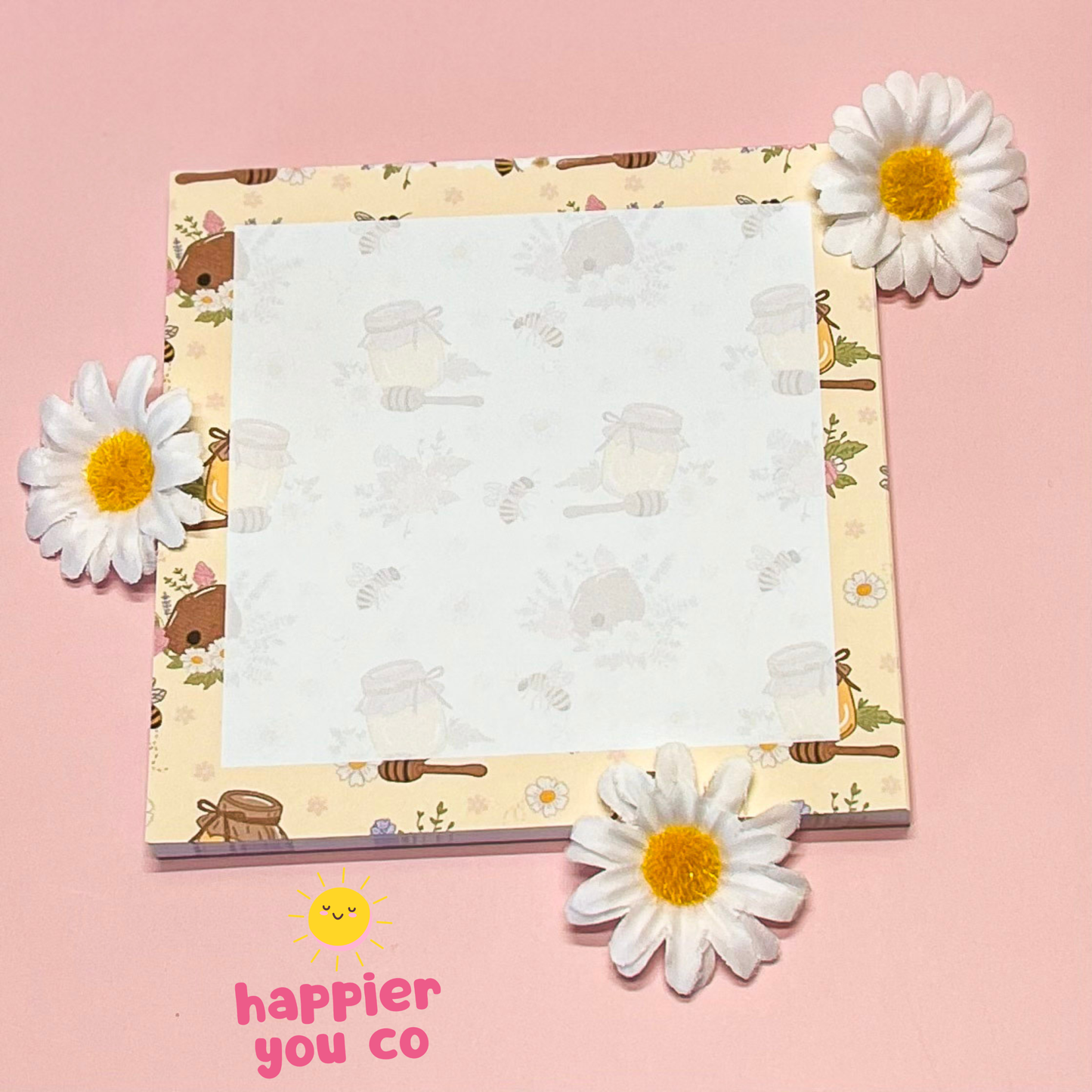Notebook with a floral design on a pink background with daisies