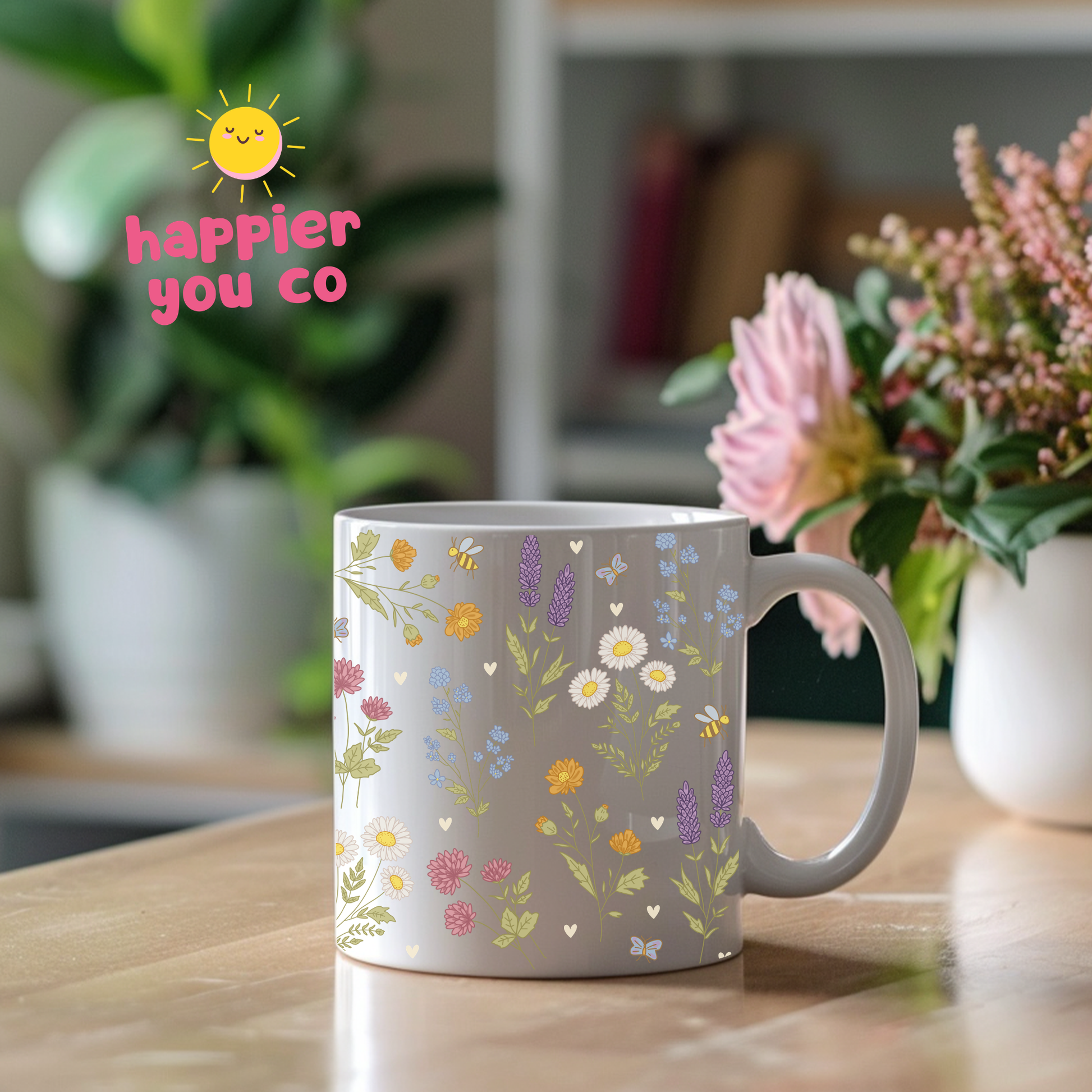 Mug with floral design on a kitchen counter, featuring the text 'happier you co'.