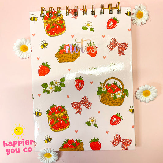 Notebook with strawberry and basket design on a pink background