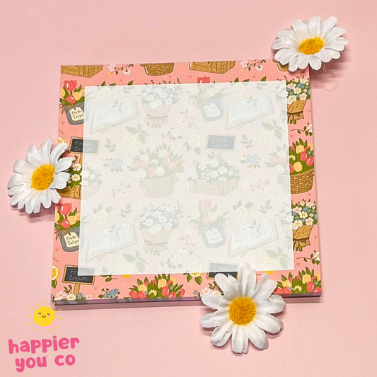 Floral notepad with daisies on a pink background, featuring 'happier you co' branding