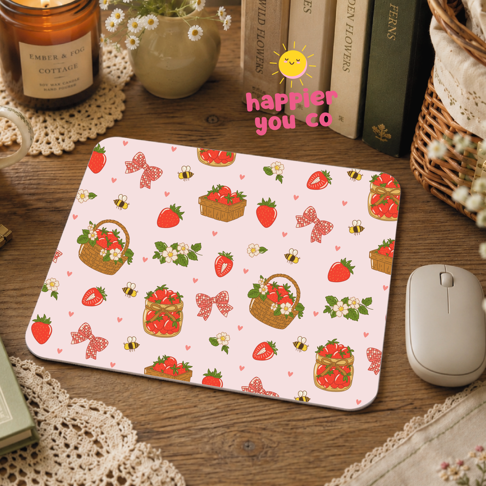 Mouse pad with strawberry and basket pattern on a wooden desk with books and a mouse.