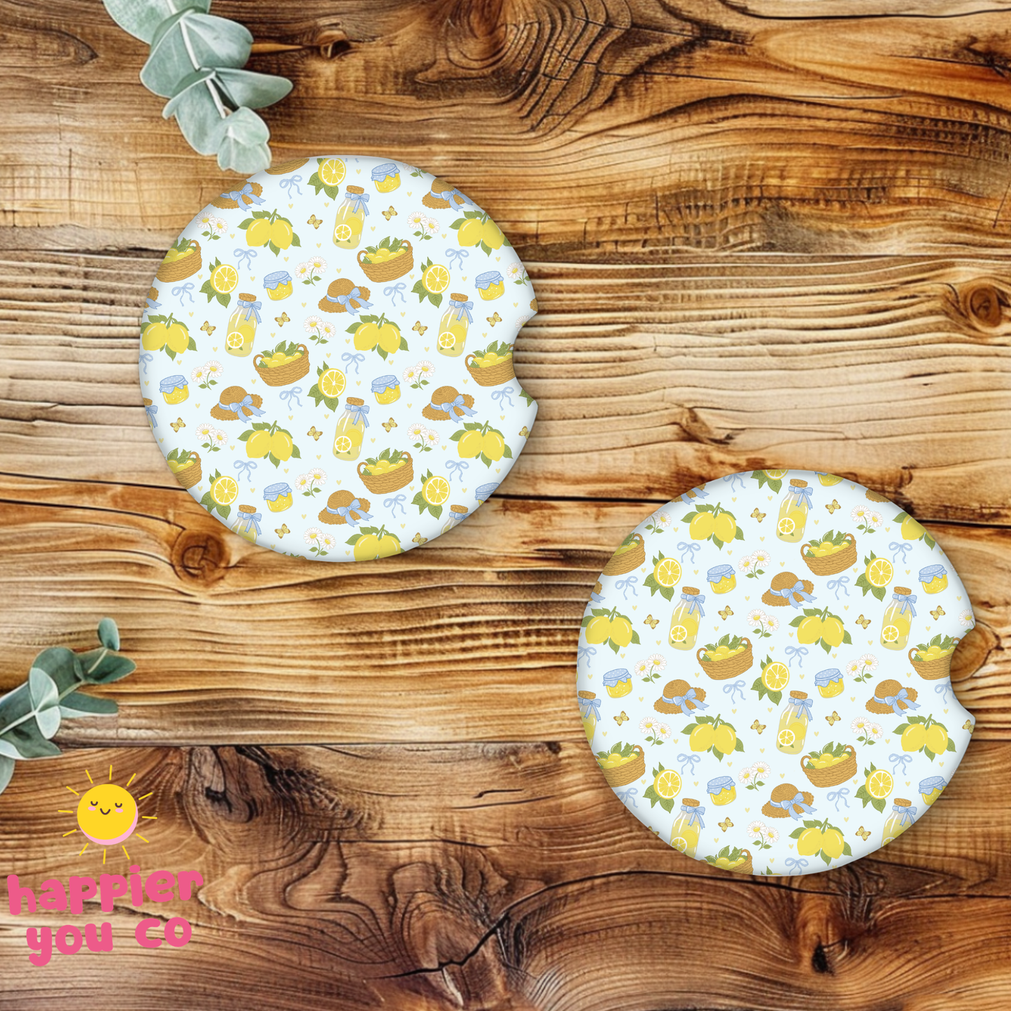 Two round coasters with a lemon pattern on a wooden surface.