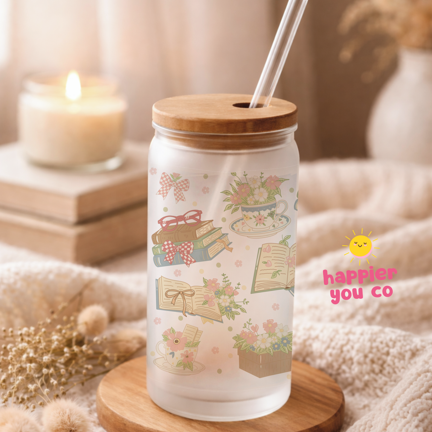 Glass tumbler with wooden lid and straw on a wooden coaster, surrounded by decorative items.