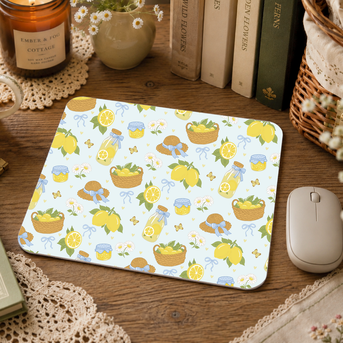 Mouse pad with lemon and basket pattern on a wooden desk with books and a candle.